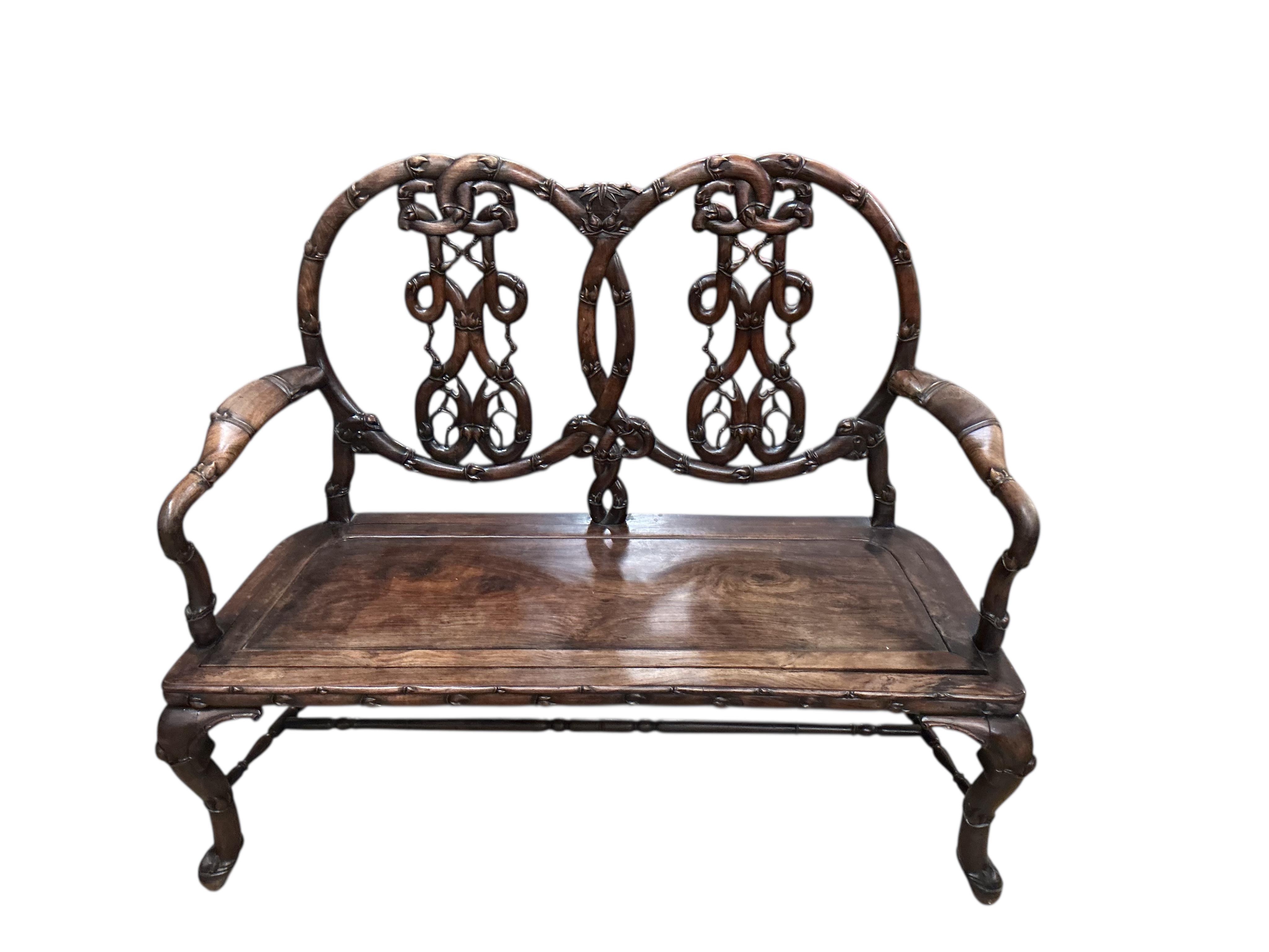 A 19th century Chinese carved hardwood chair back settee, width 116cm, depth 46cm, height 102cm